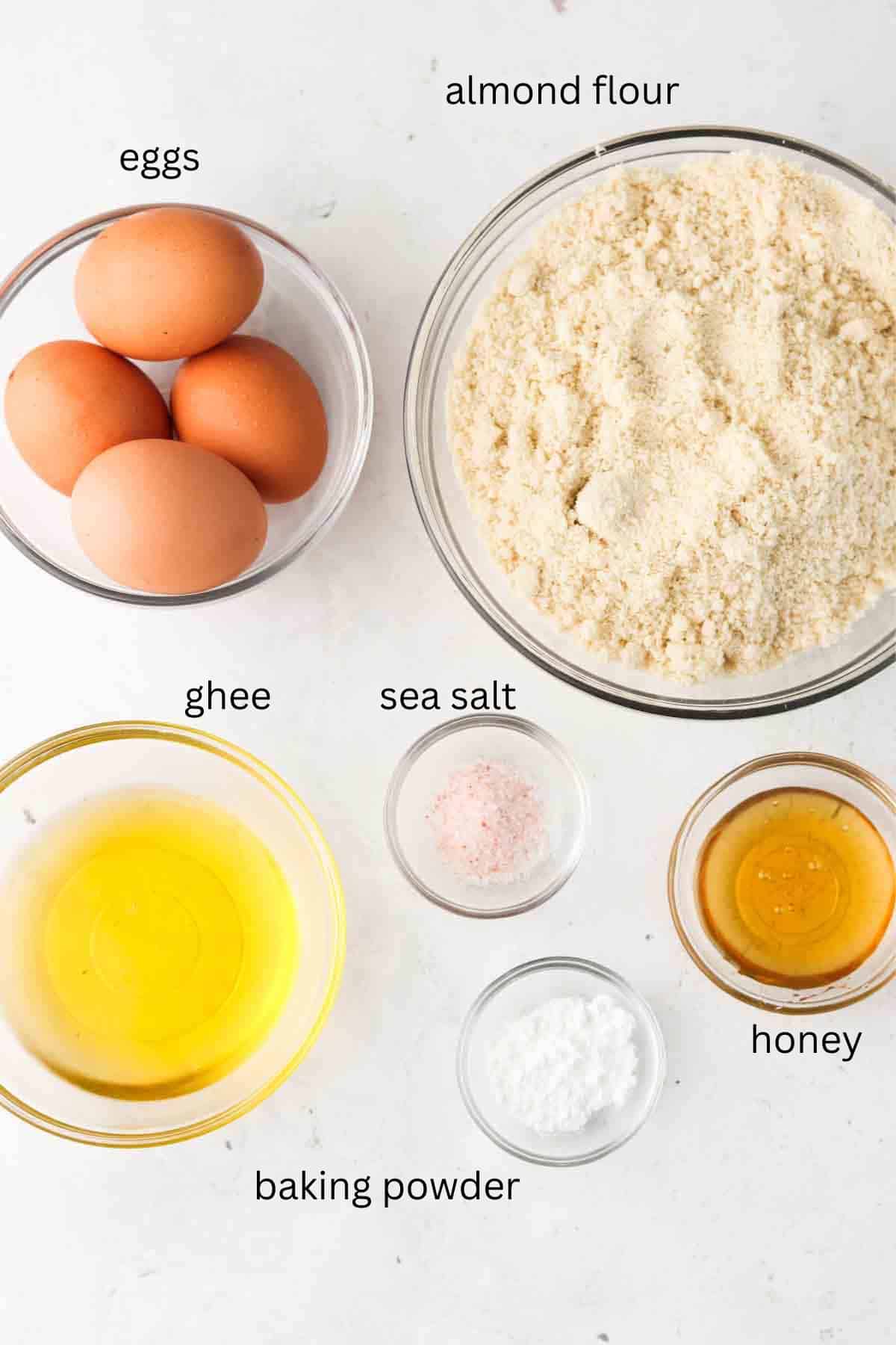 Biscuit ingredients laid out in small glass bowls on the counter. 