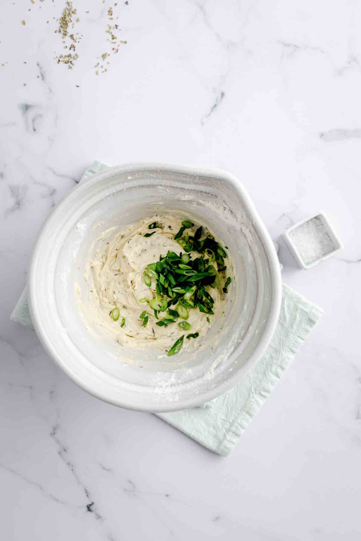 Tapioca flour, coconut flour, baking soda, garlic powder, green onions, dried thyme, dried oregano, olive oil, water, and gelatin in a mixing bowl.