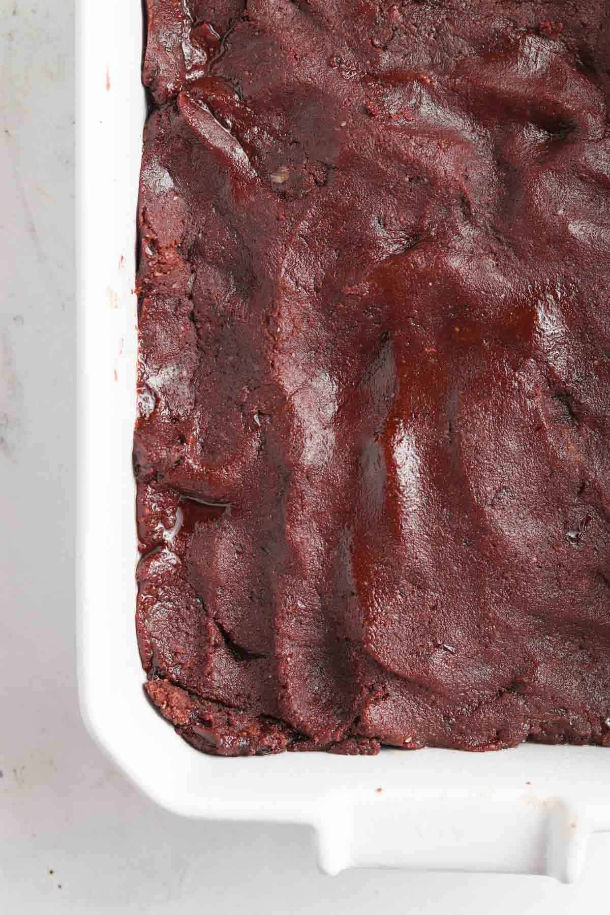 Raw brownie batter in a casserole dish. 