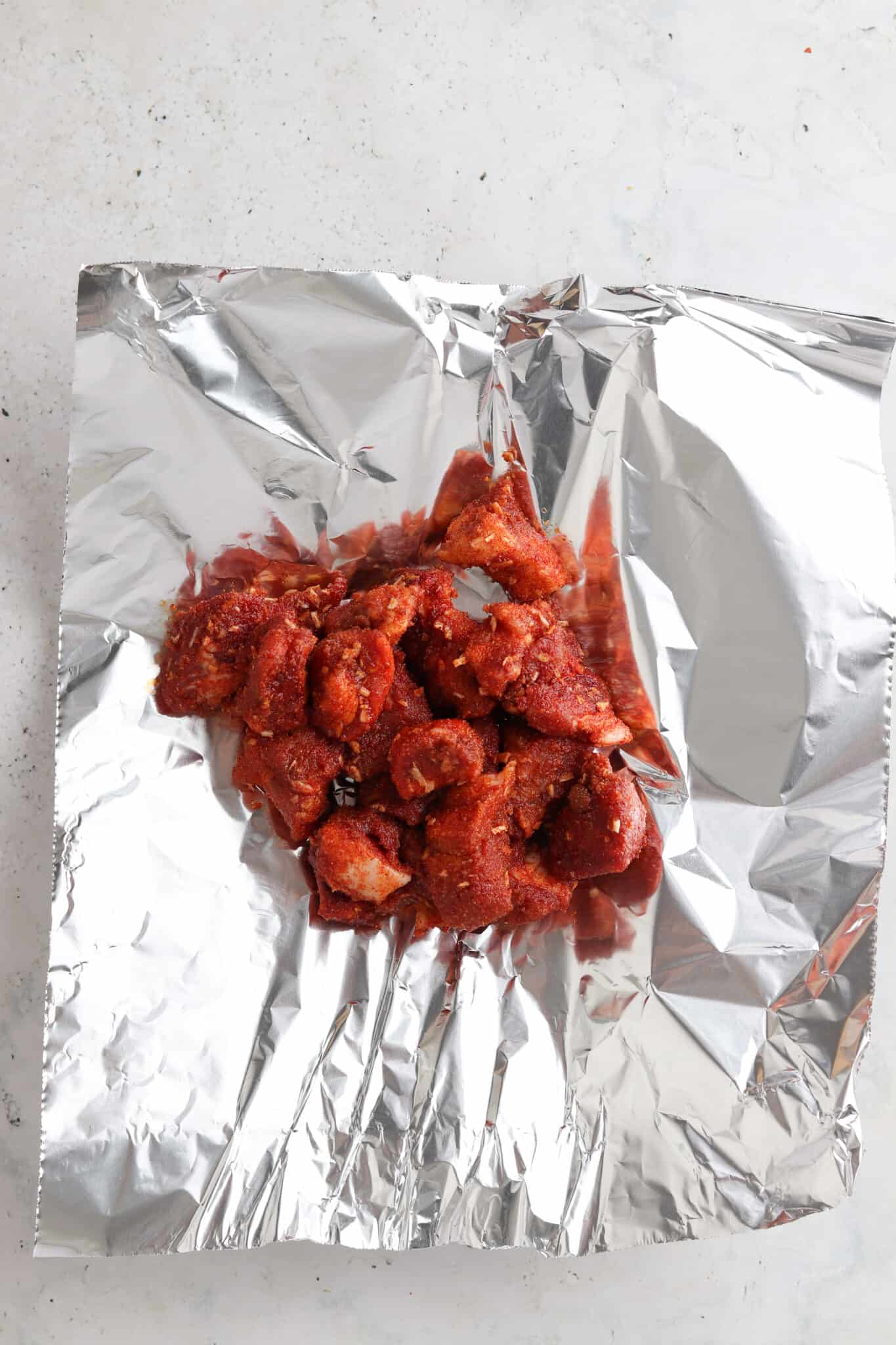Marinated pork belly on a piece of foil.