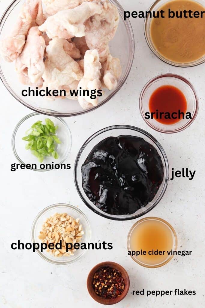 Peanut butter and jelly wing ingredients in small glass bowls.