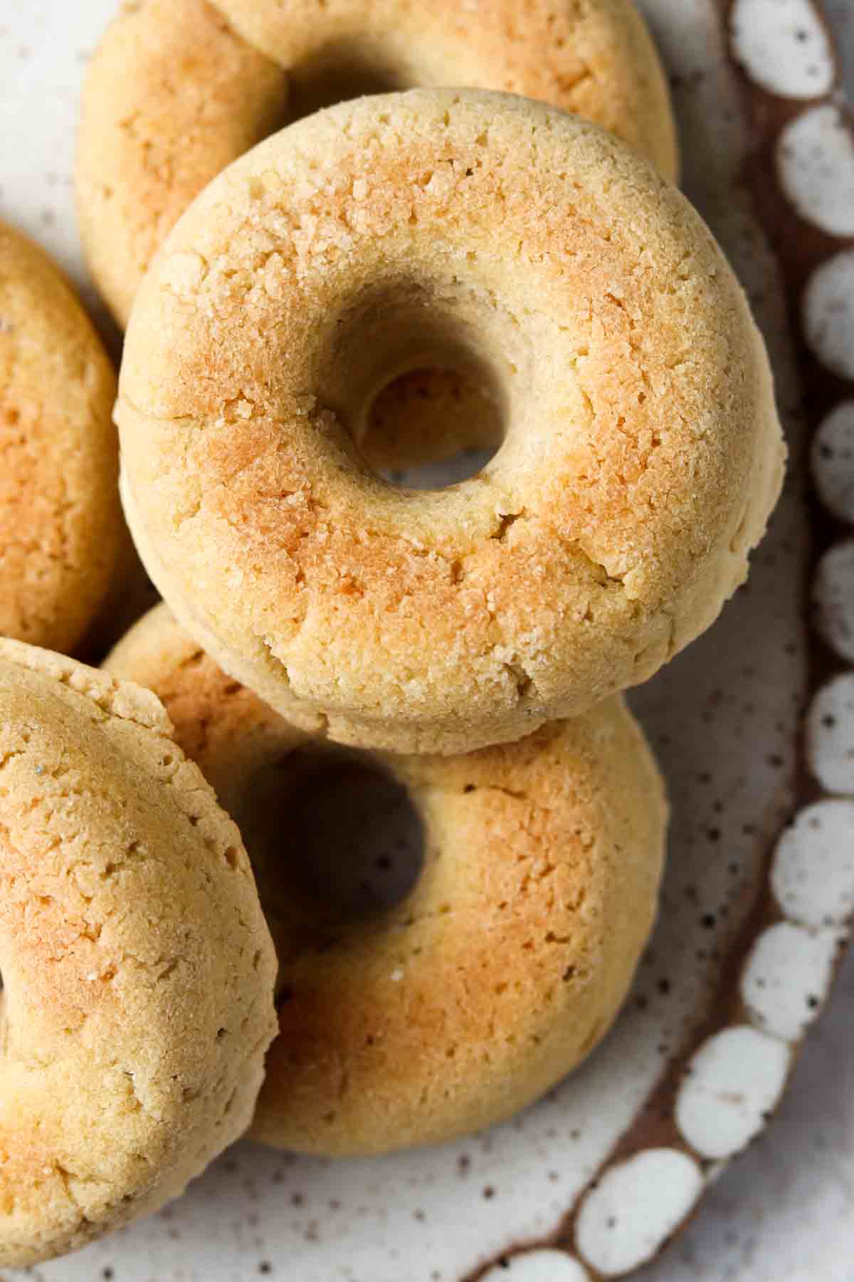 Bagels stacked up on a pretty scalloped platter. 