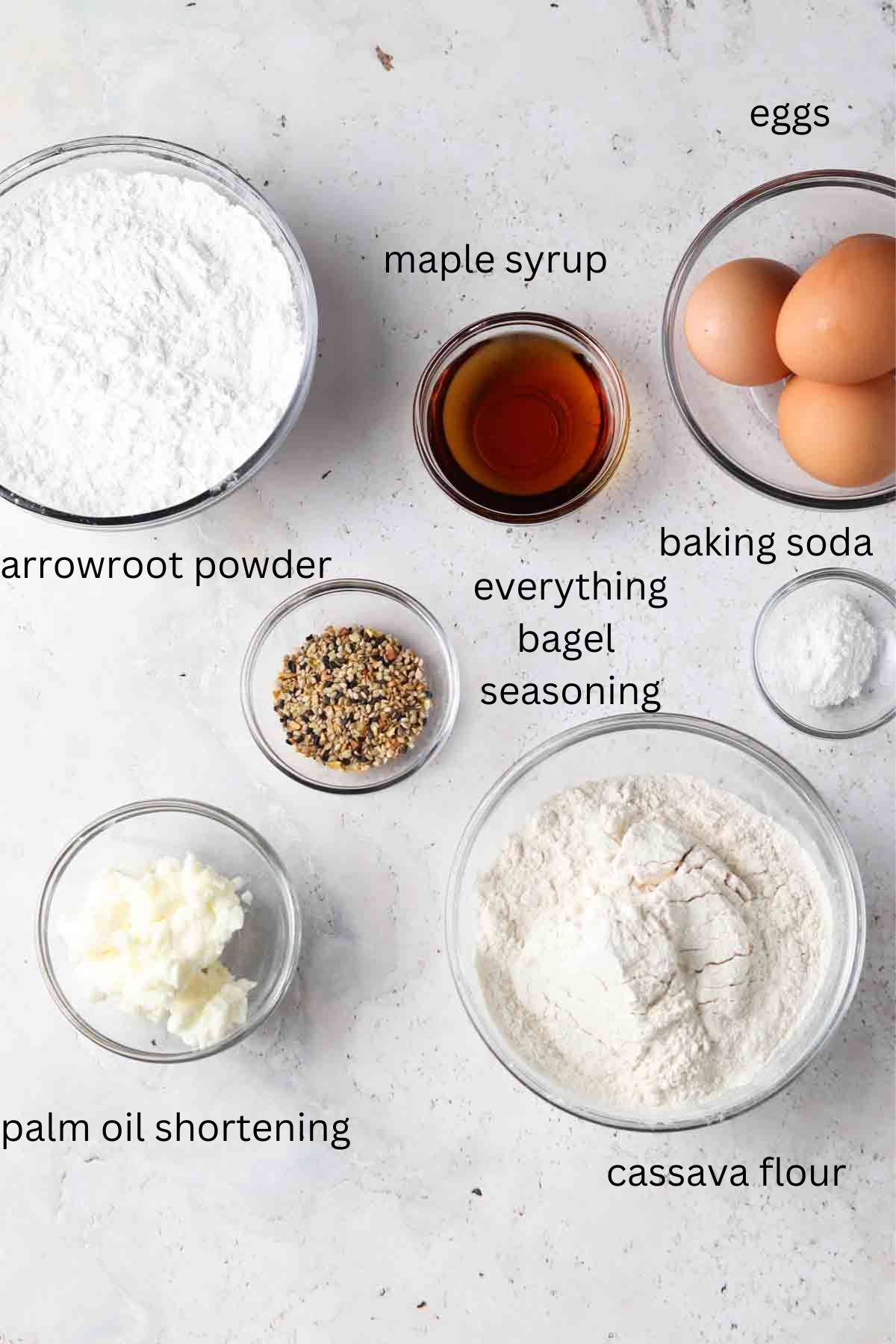 Bagel ingredients in small glass bowls on the counter top.