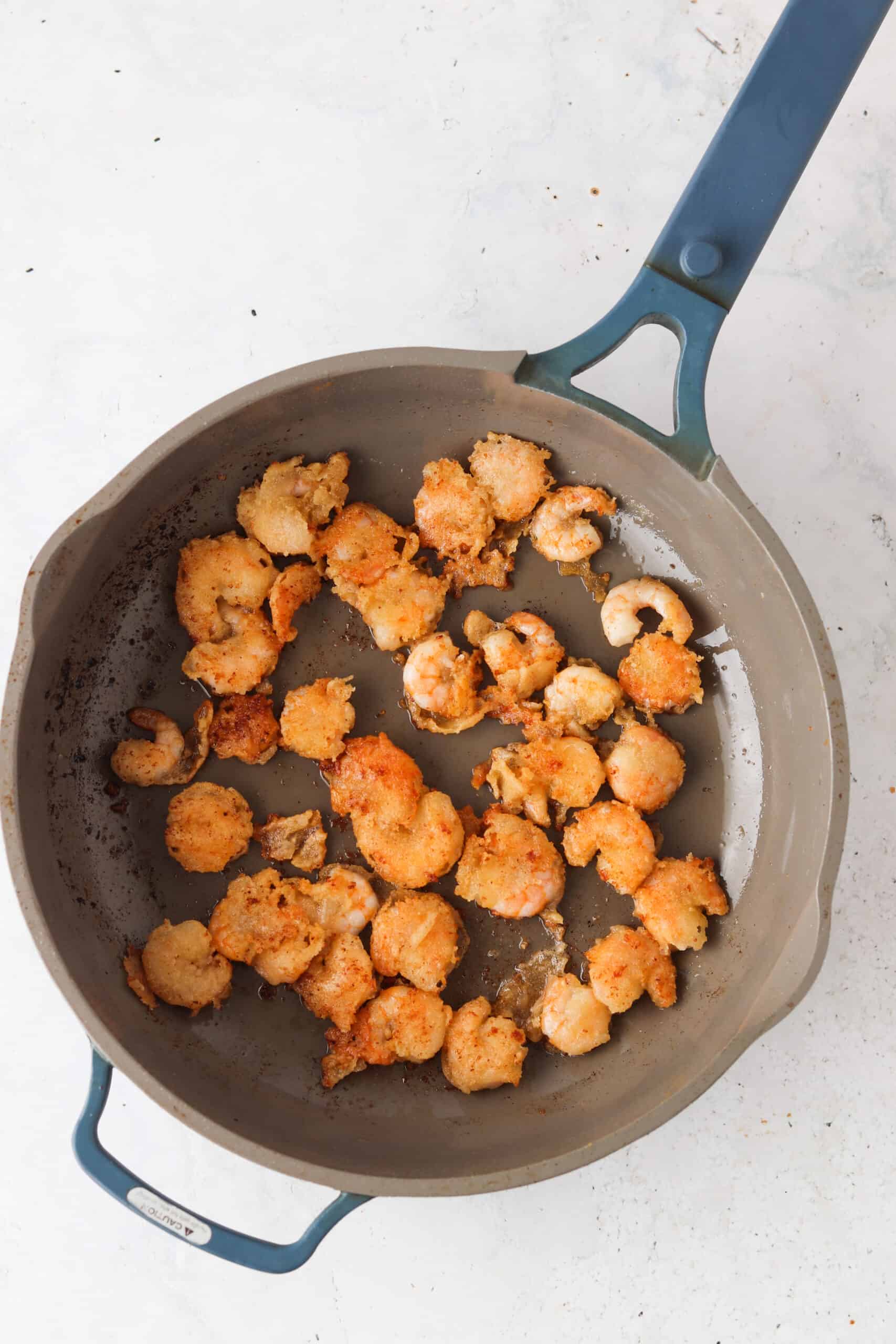 Breaded shrimp in a frying pan.