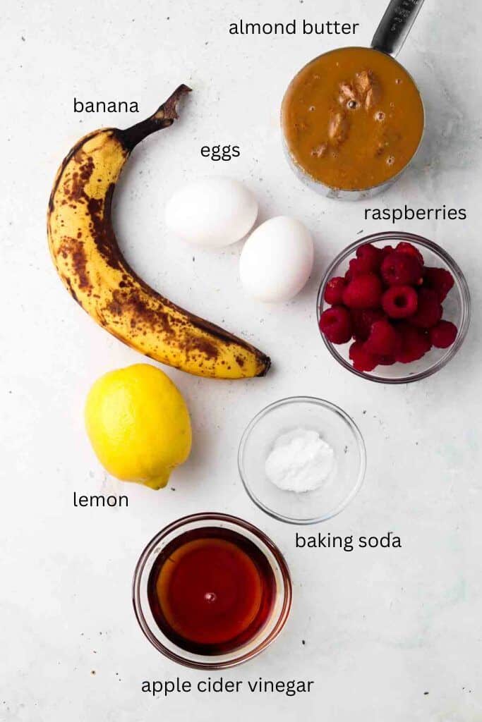 Ingredients for raspberry lemon muffins in glass bowls on a tabletop.