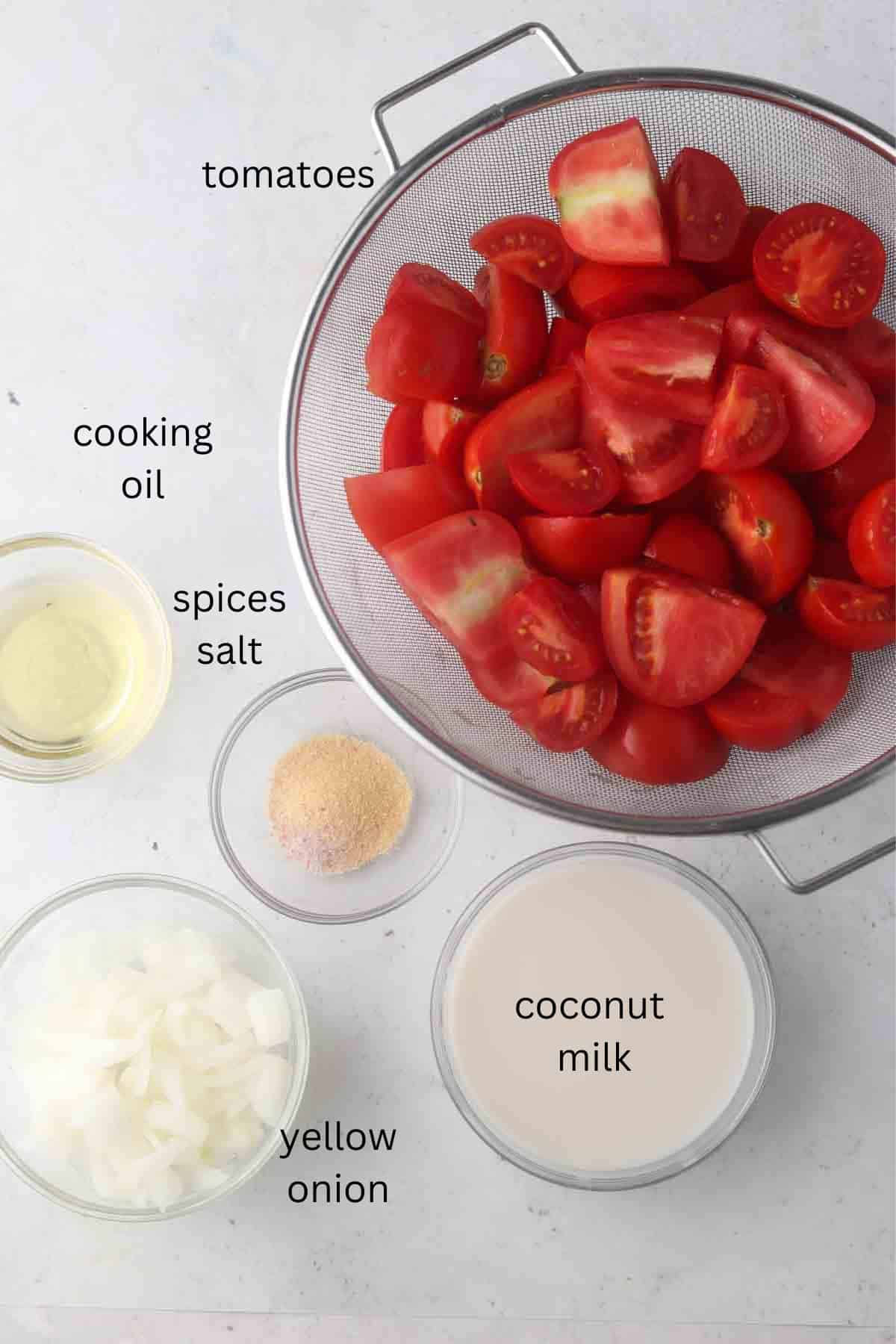 Tomato soup ingredients laid out in small bowls on the counter top.