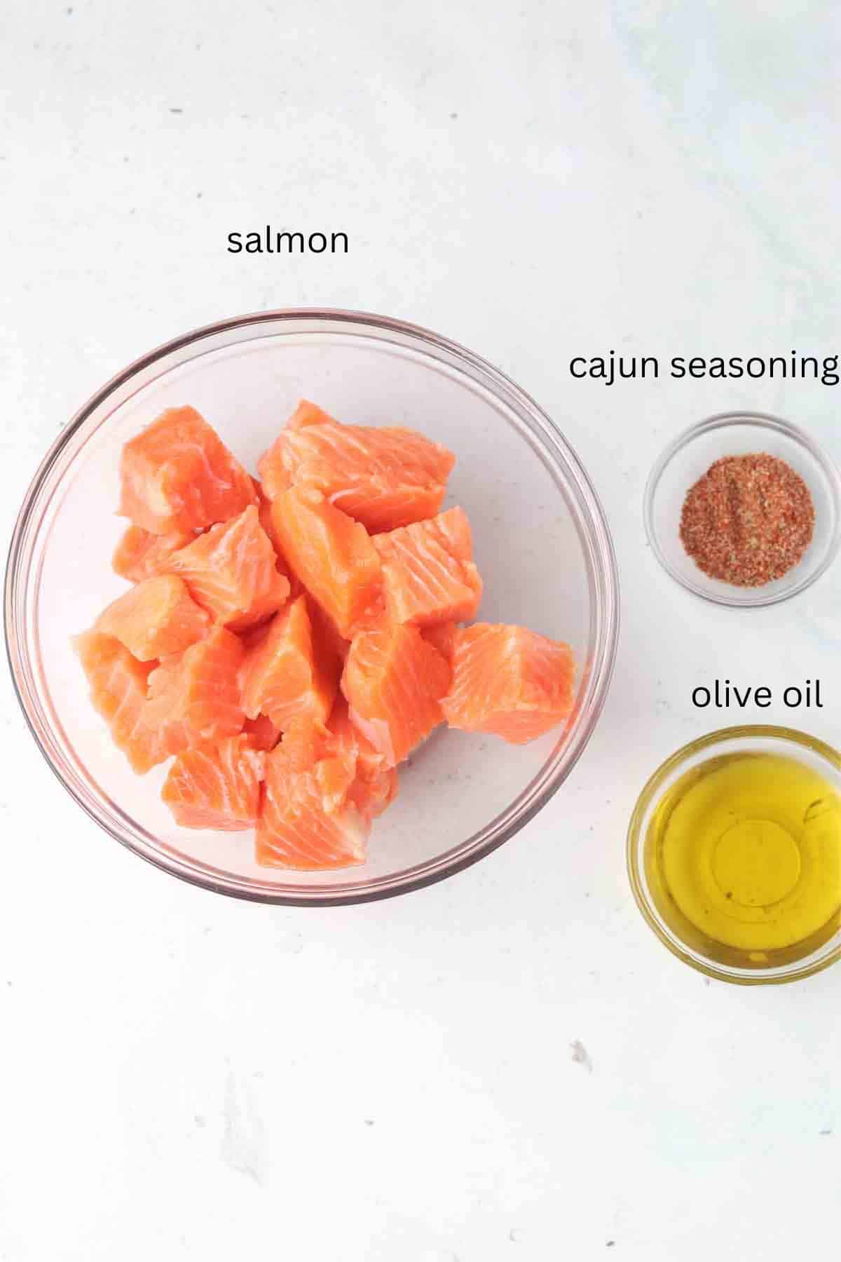 Salmon bites ingredients in glass bowls on a tabletop.