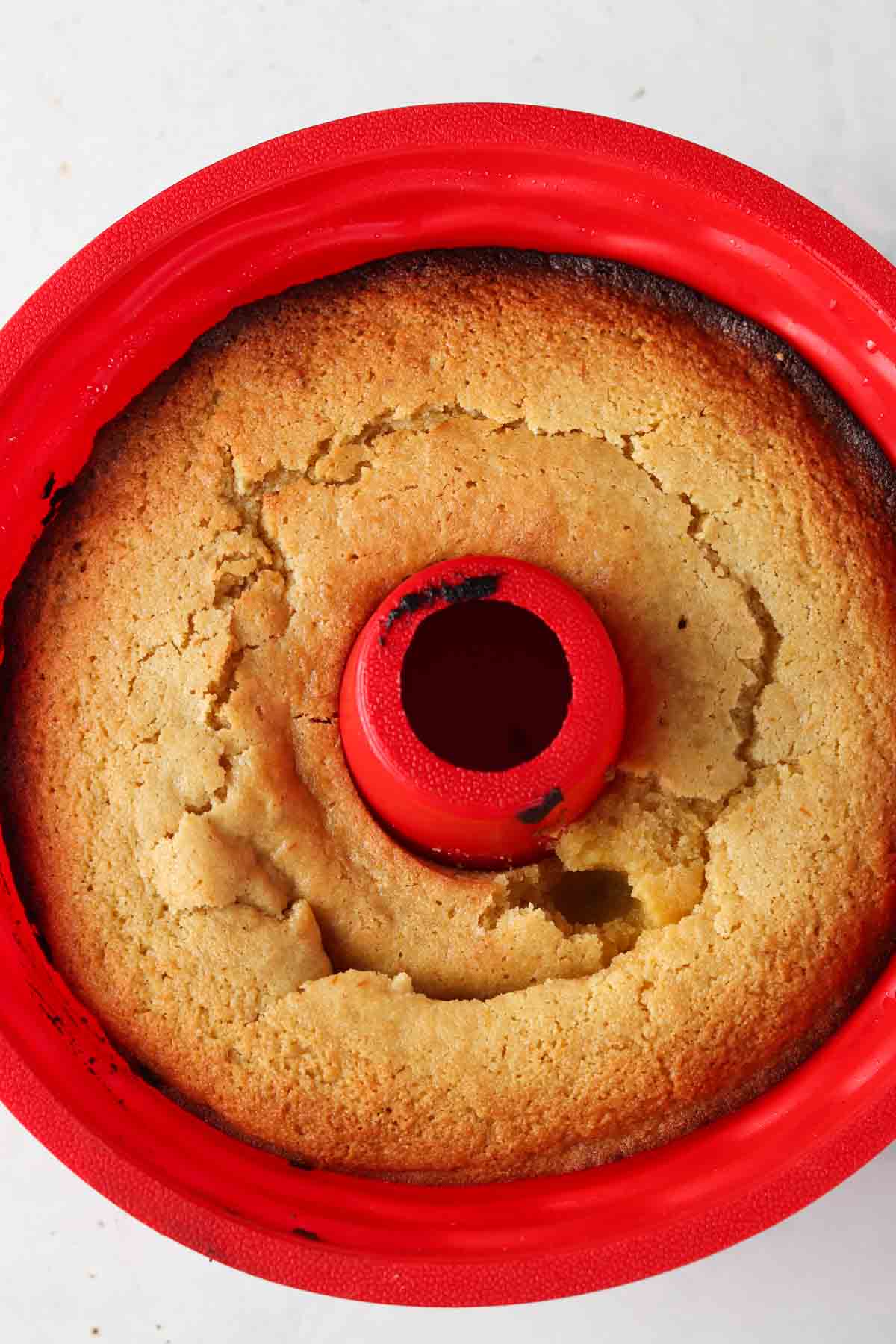 Baked lemon cake in a red silicone pan.