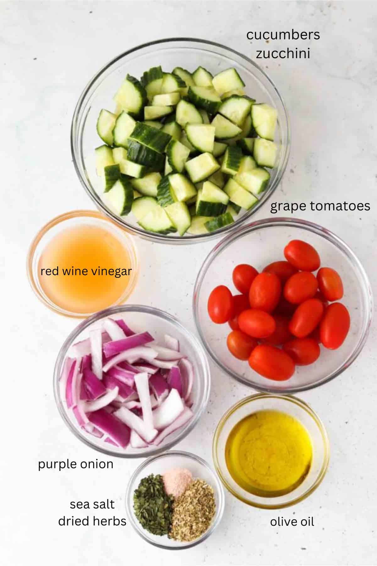 Greek salad ingredients in glass bowls. 