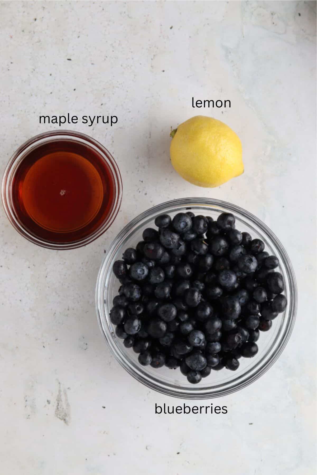 Blueberry maple jam ingredients in small glass bowls.