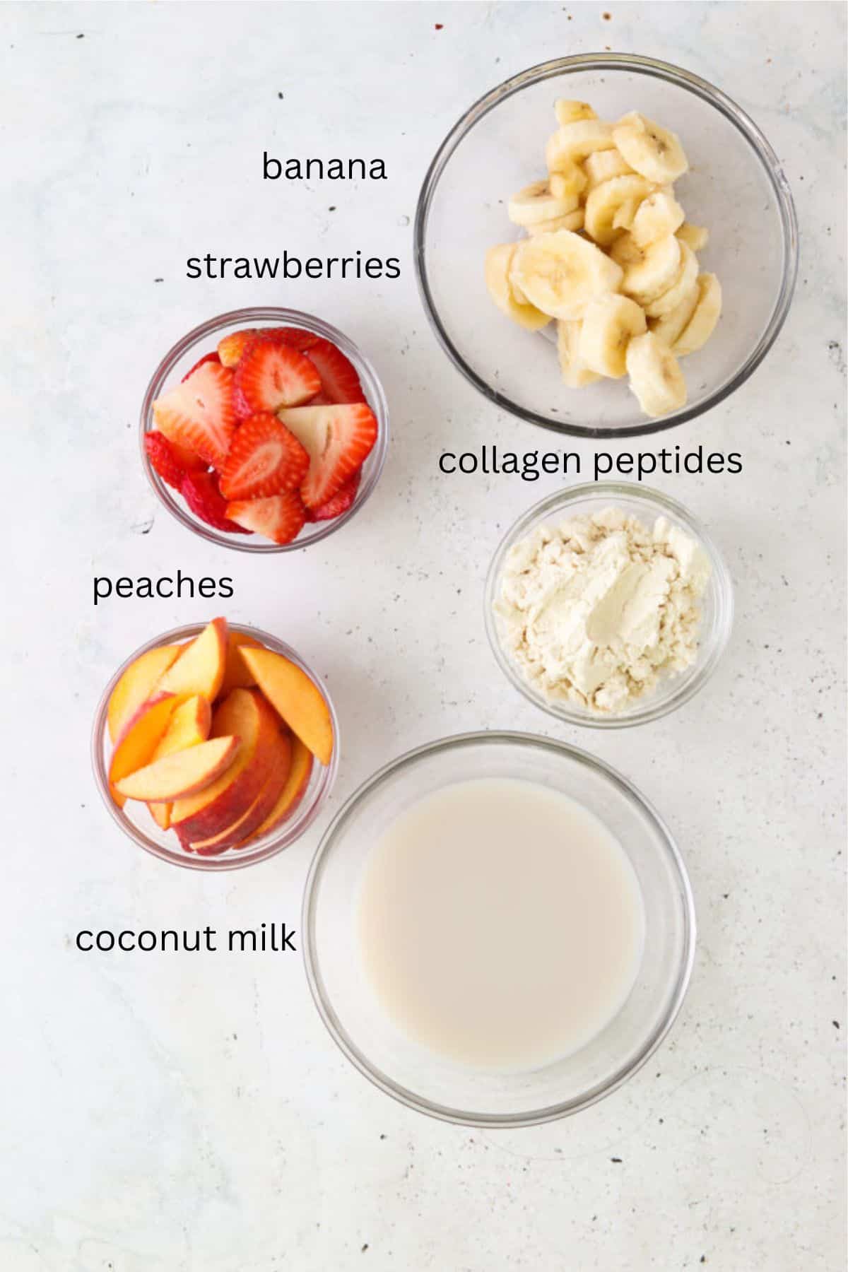 Strawberry peach smoothie ingredients in small glass bowls.