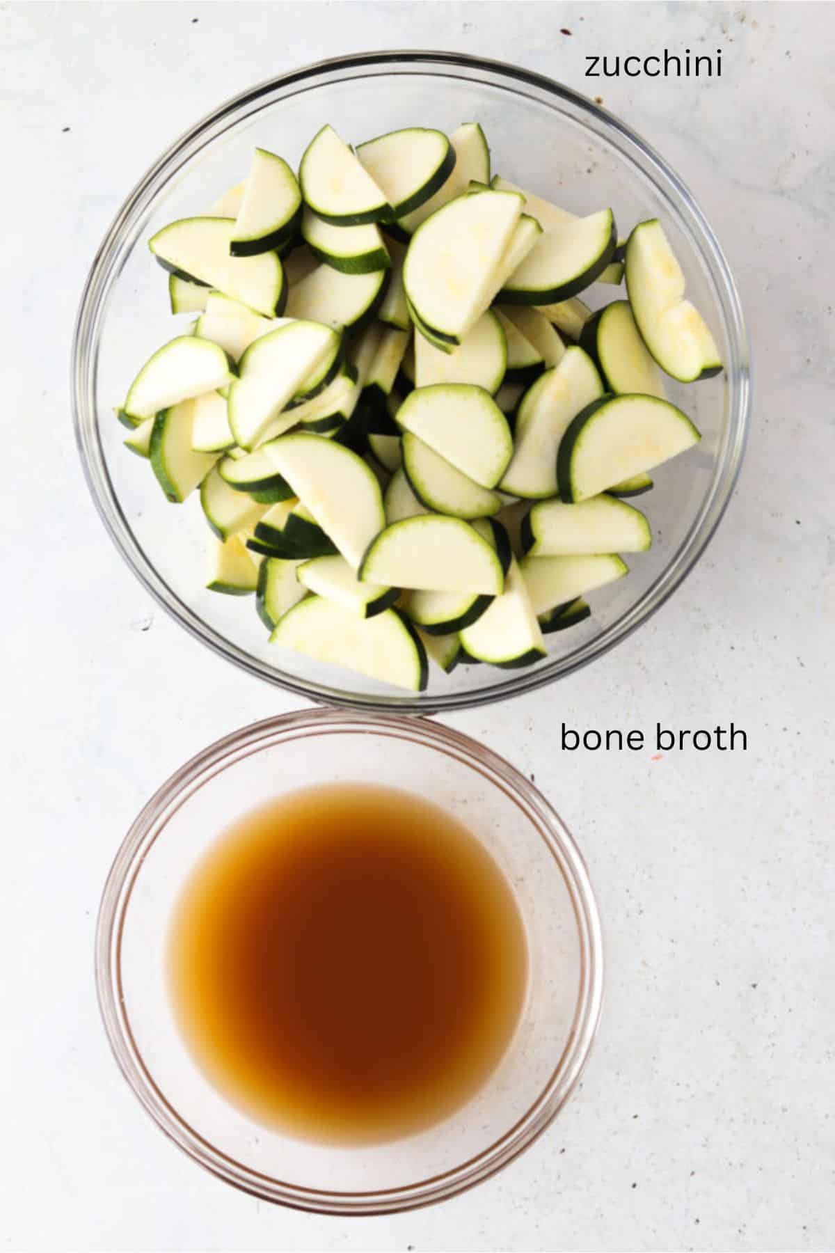 Zucchini and bone broth in glass bowls.