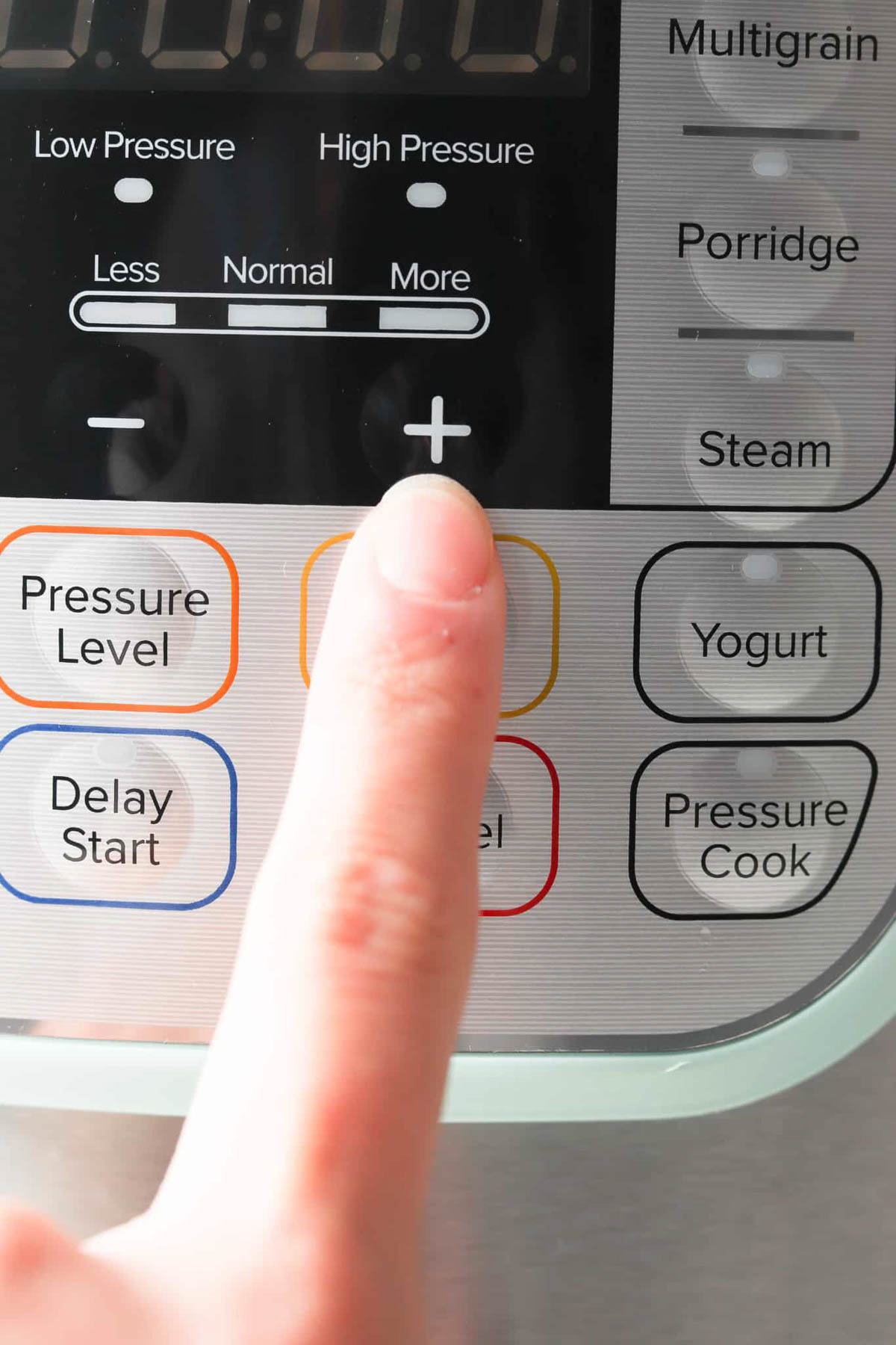 Instant pot front controls with finger increasing cooking time. 