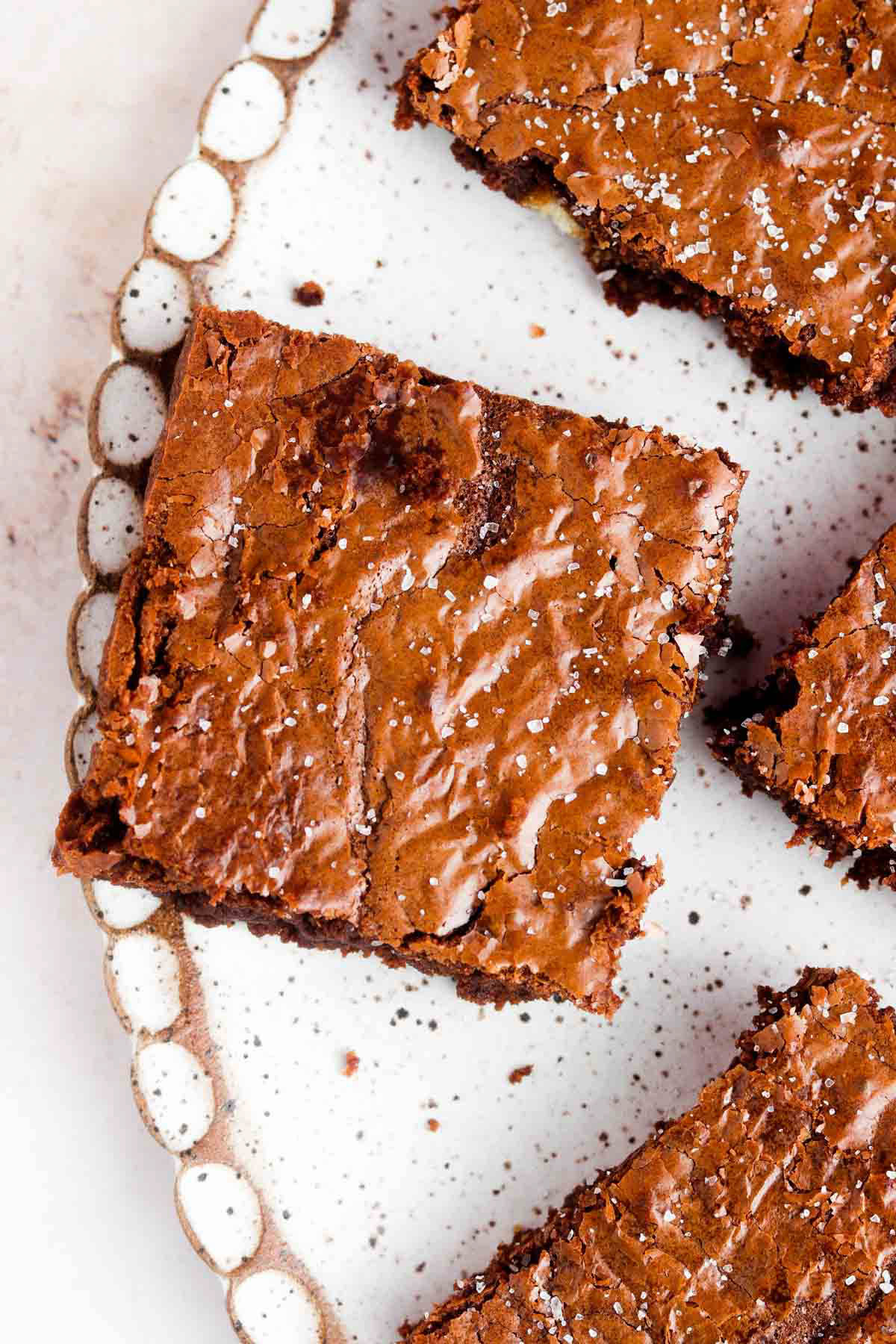 Gluten free brownies cut into squares on a scalloped platter.