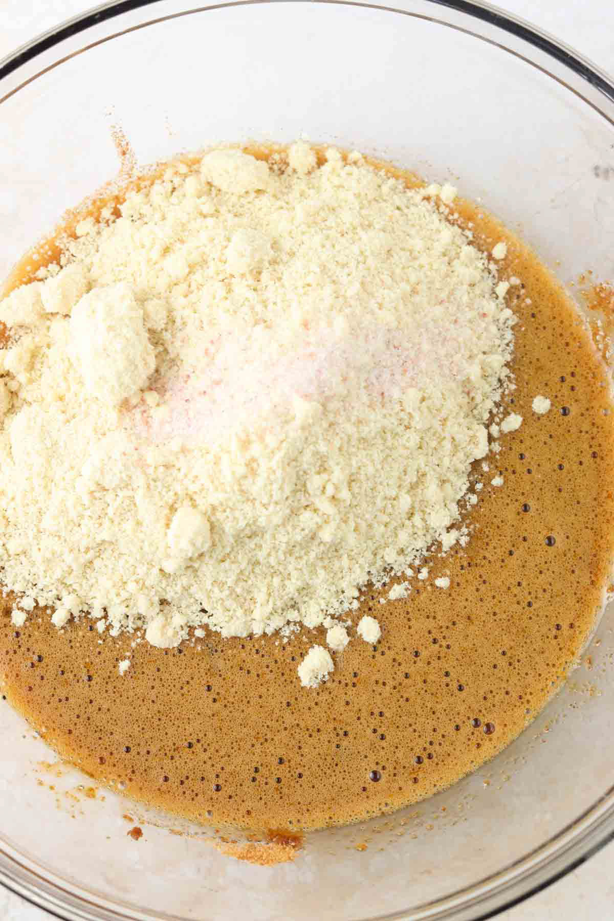 Dry ingredients being added to mixing bowl with wet ingredients for dairy free brownies. 