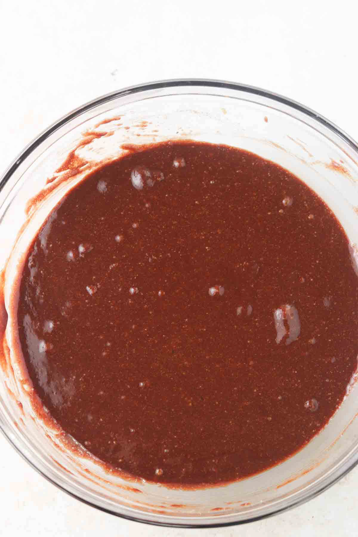 Diary free brownie batter mixed together in a glass mixing bowl. 