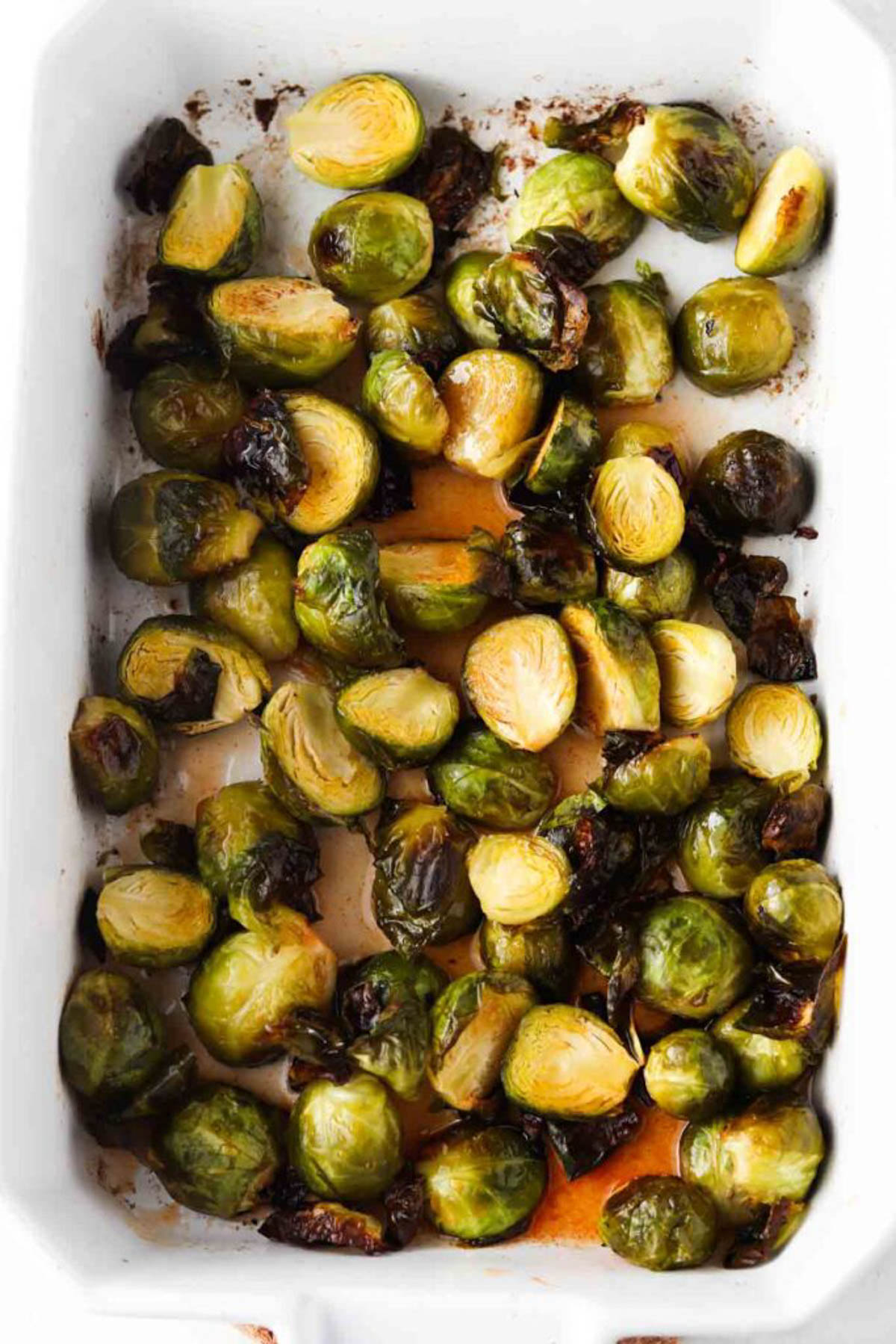 Cooked honey sriracha brussel sprouts in a casserole dish. 