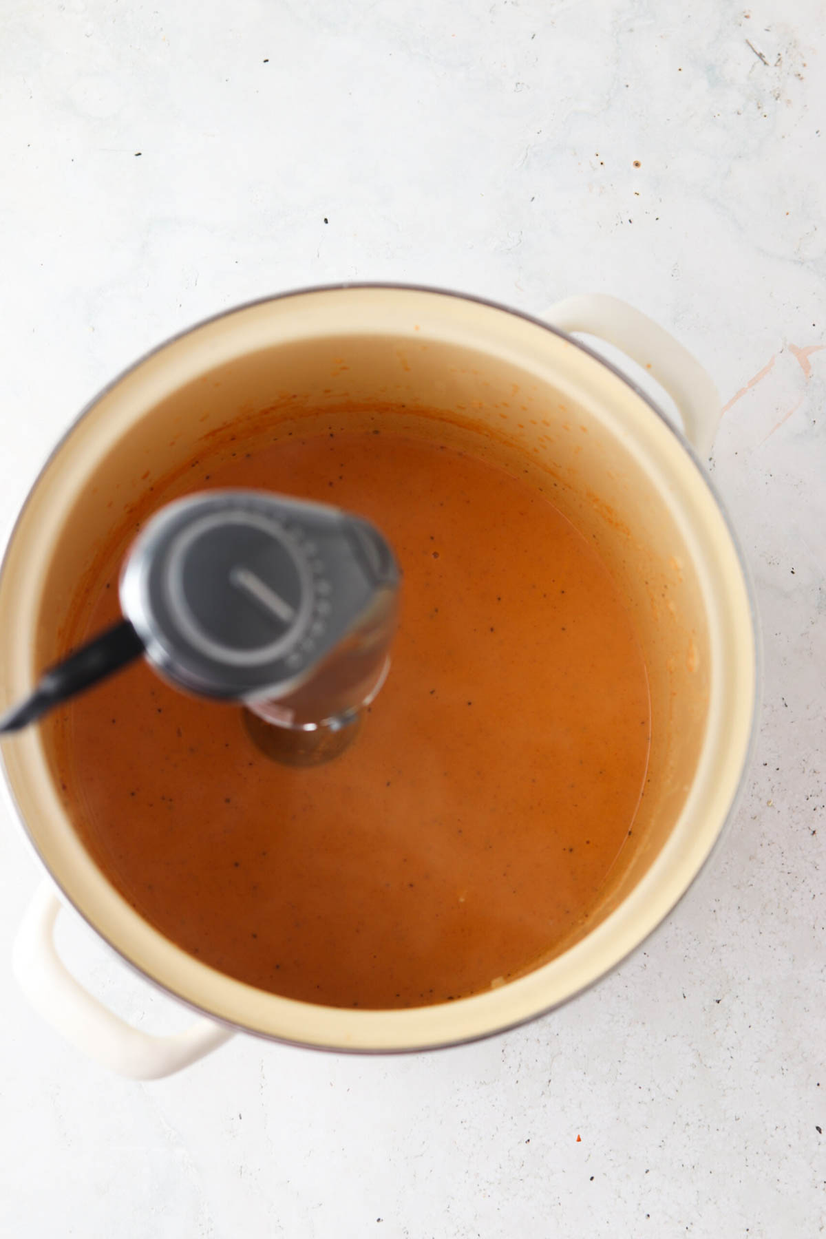 Dairy free lobster bisque in a stock pot after being blended with immersion blender to be smooth.