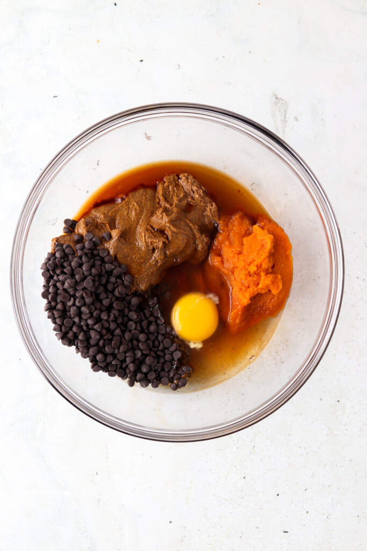 Gluten free pumpkin cookie ingredients in a glass mixing bowl unmixed.