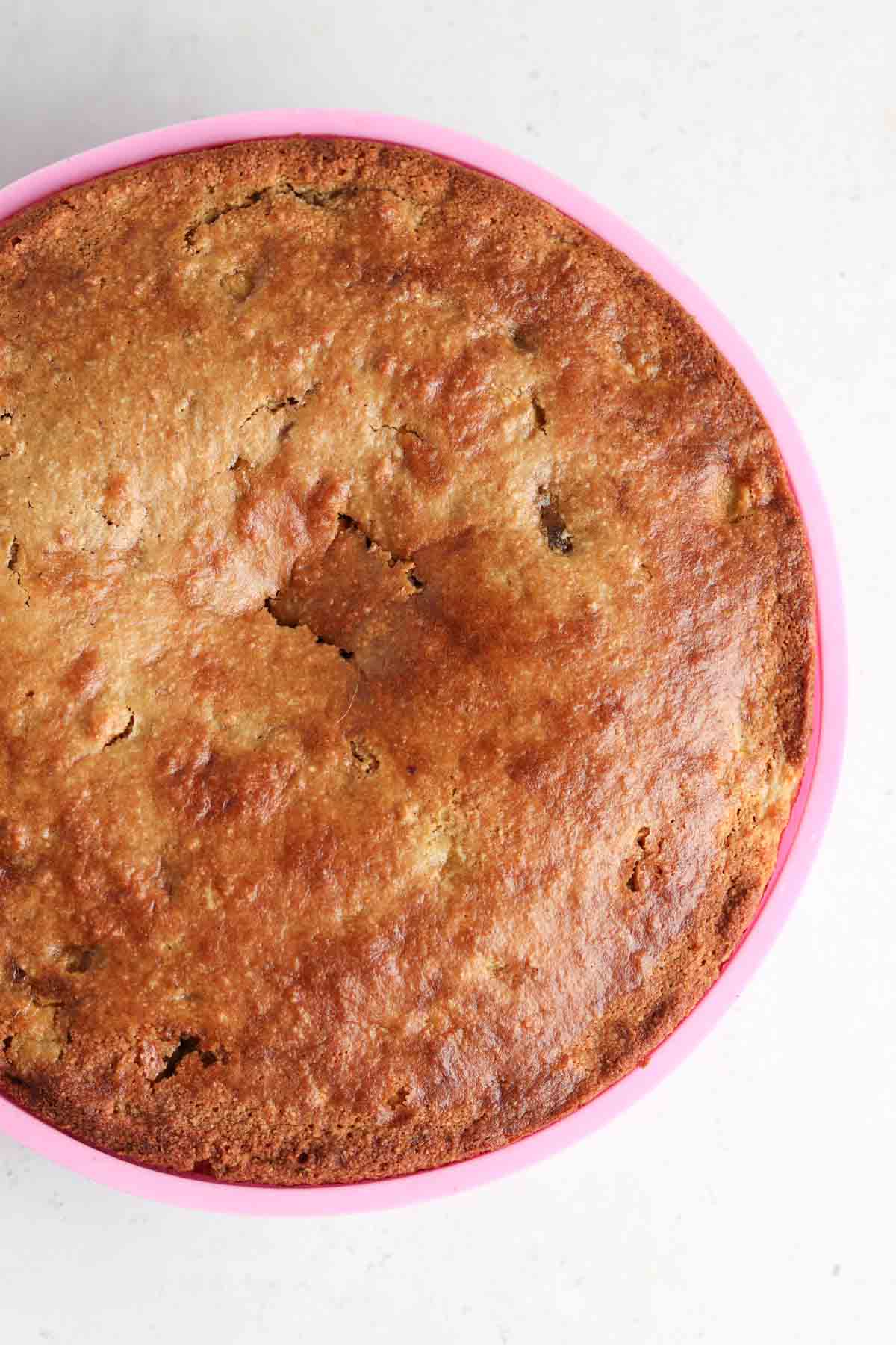 Baked cake in a pink silicone cake pan.