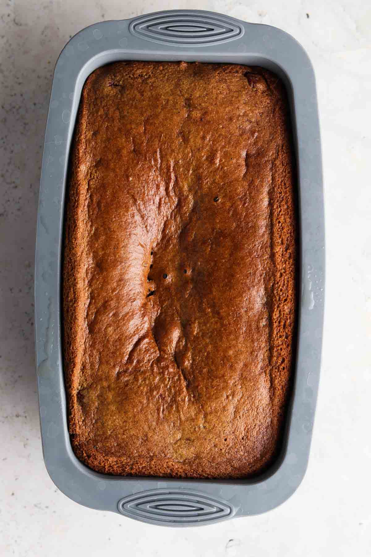 Gluten free orange cake cooling in a loaf pan.