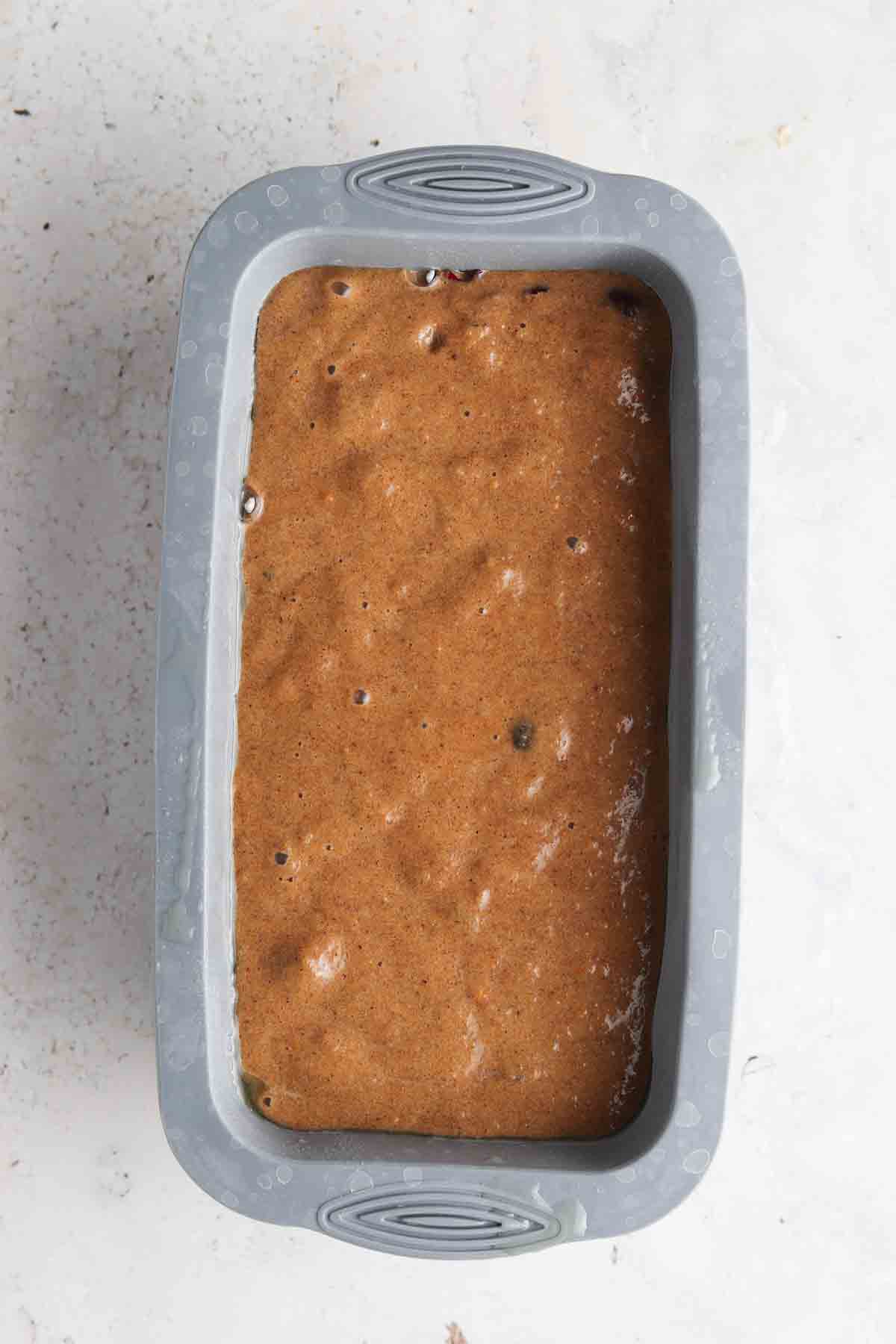 Cranberry orange batter in a silicone baking pan.