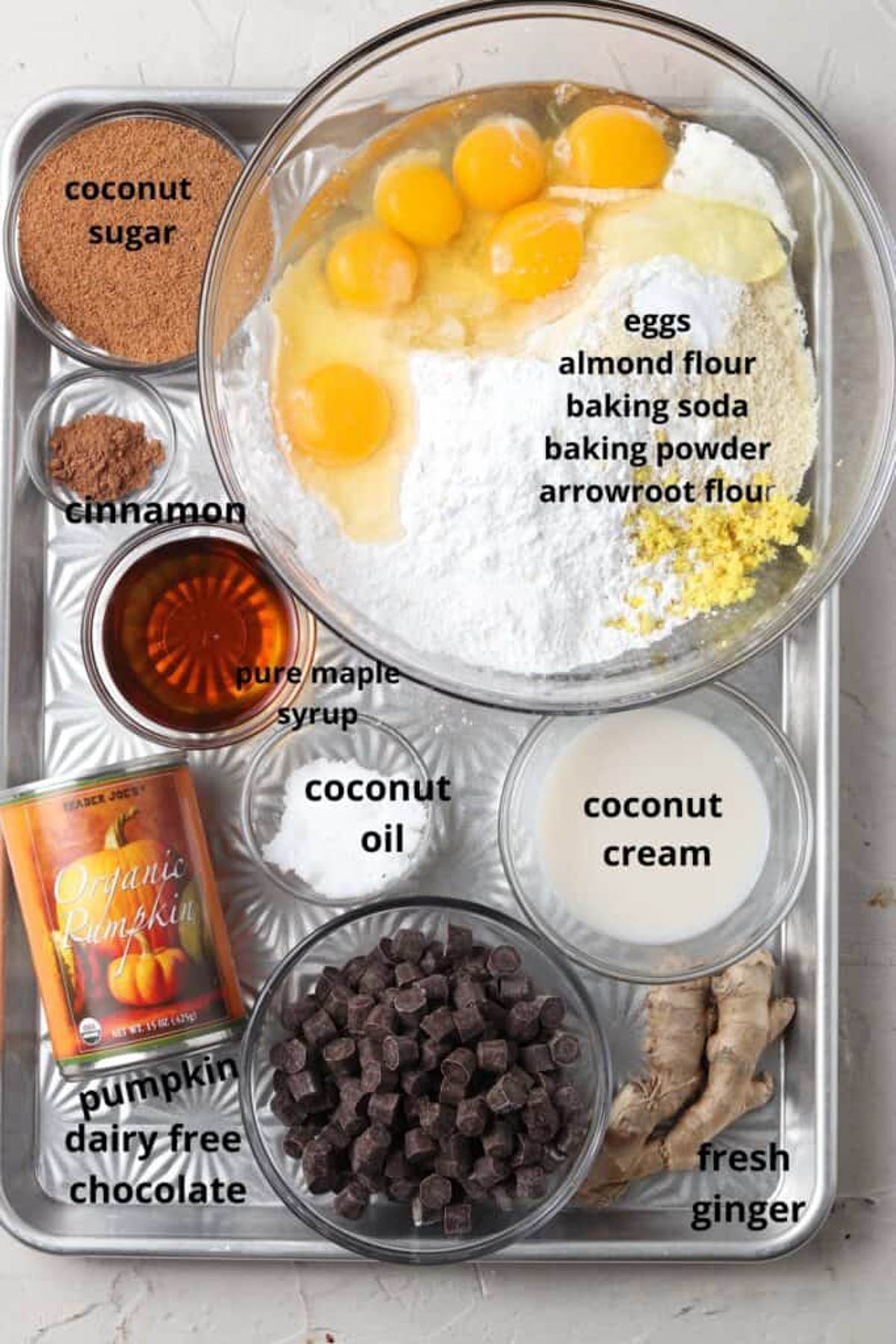 Gluten free pumpkin cake ingredients in small glass bowls on a silver tray. 