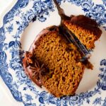 Pumpkin cake with chocolate sauce on top on a blue plate.