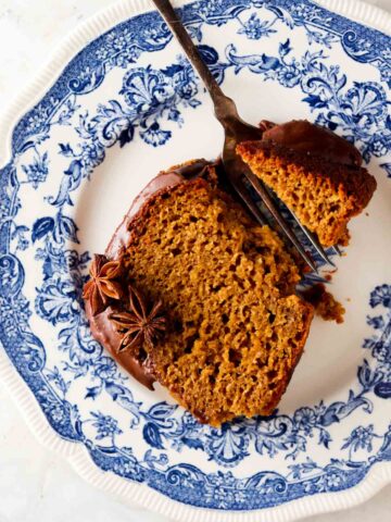 Pumpkin cake with chocolate sauce on top on a blue plate.
