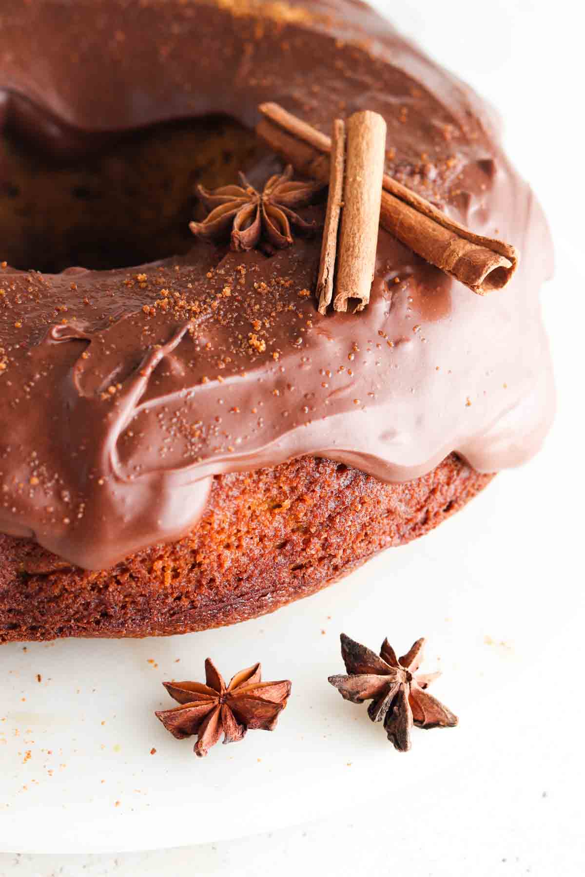 Pumpkin cake on a cake stand with coconut sugar on top.