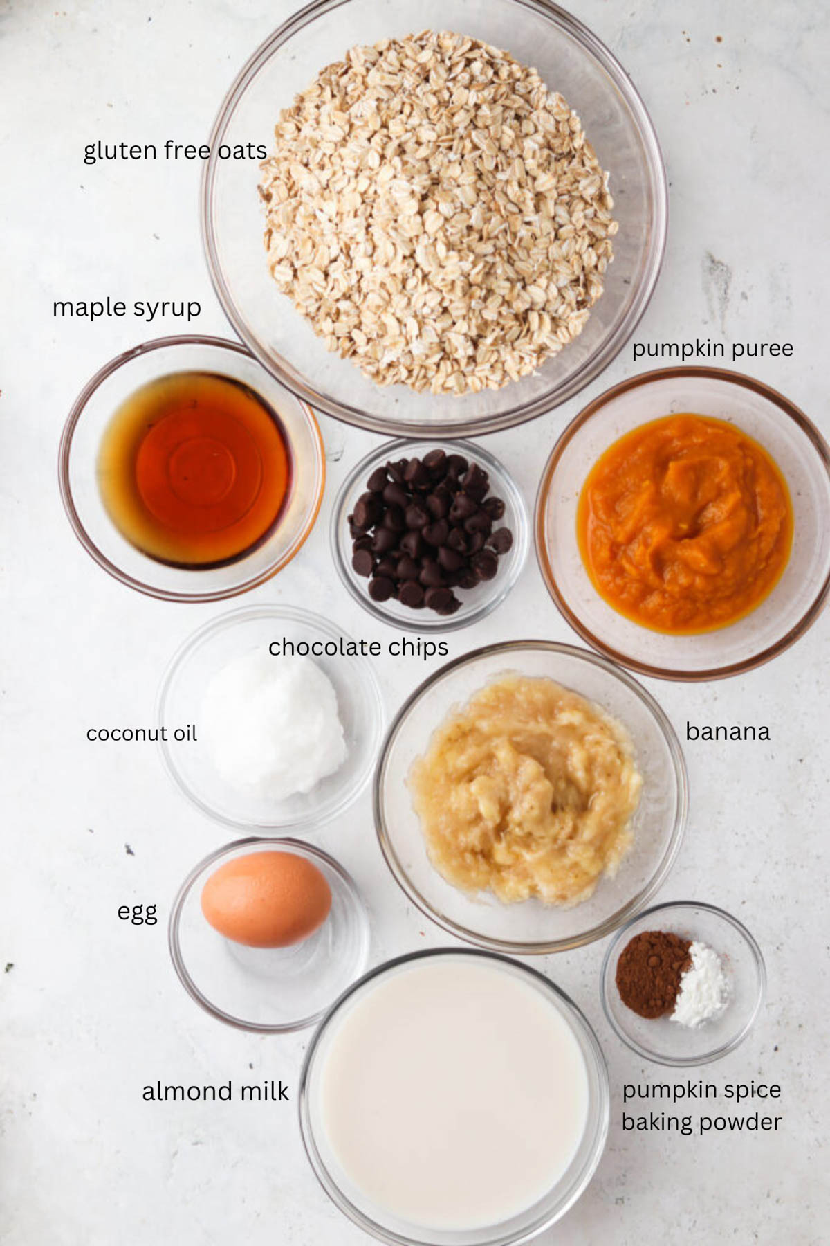 Pumpkin baked oatmeal ingredients in glass bowls. 