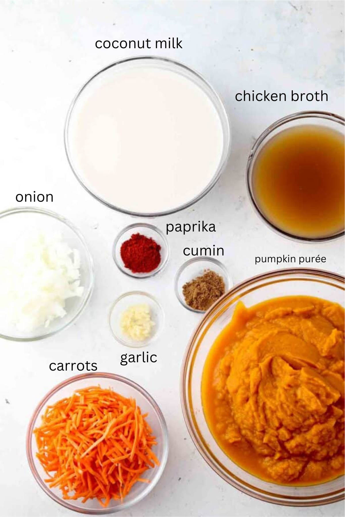 Slow cooker pumpkin soup ingredients in glass bowls. 