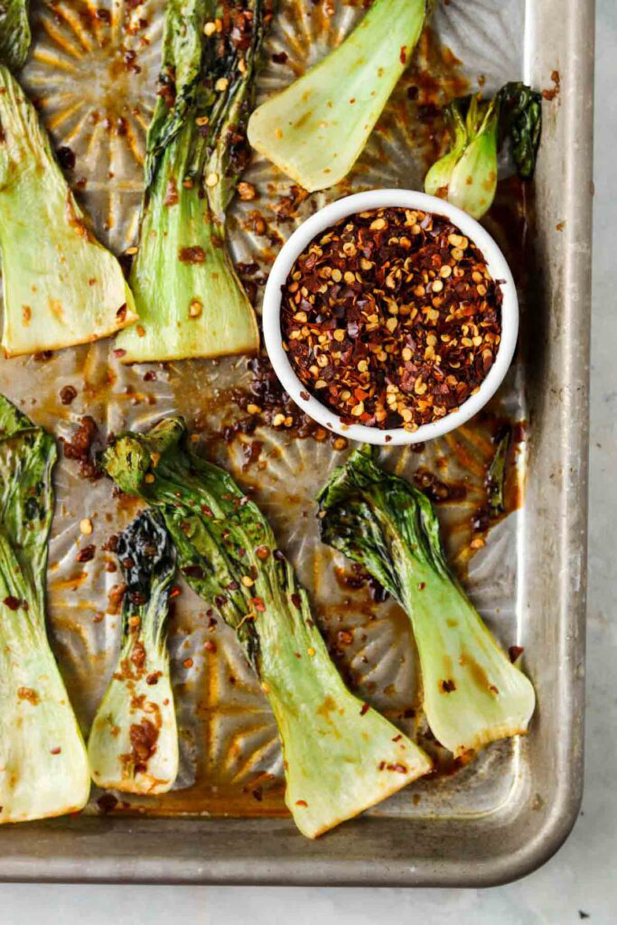 Roasted bok choy on a sheet pan with red pepper flakes, 