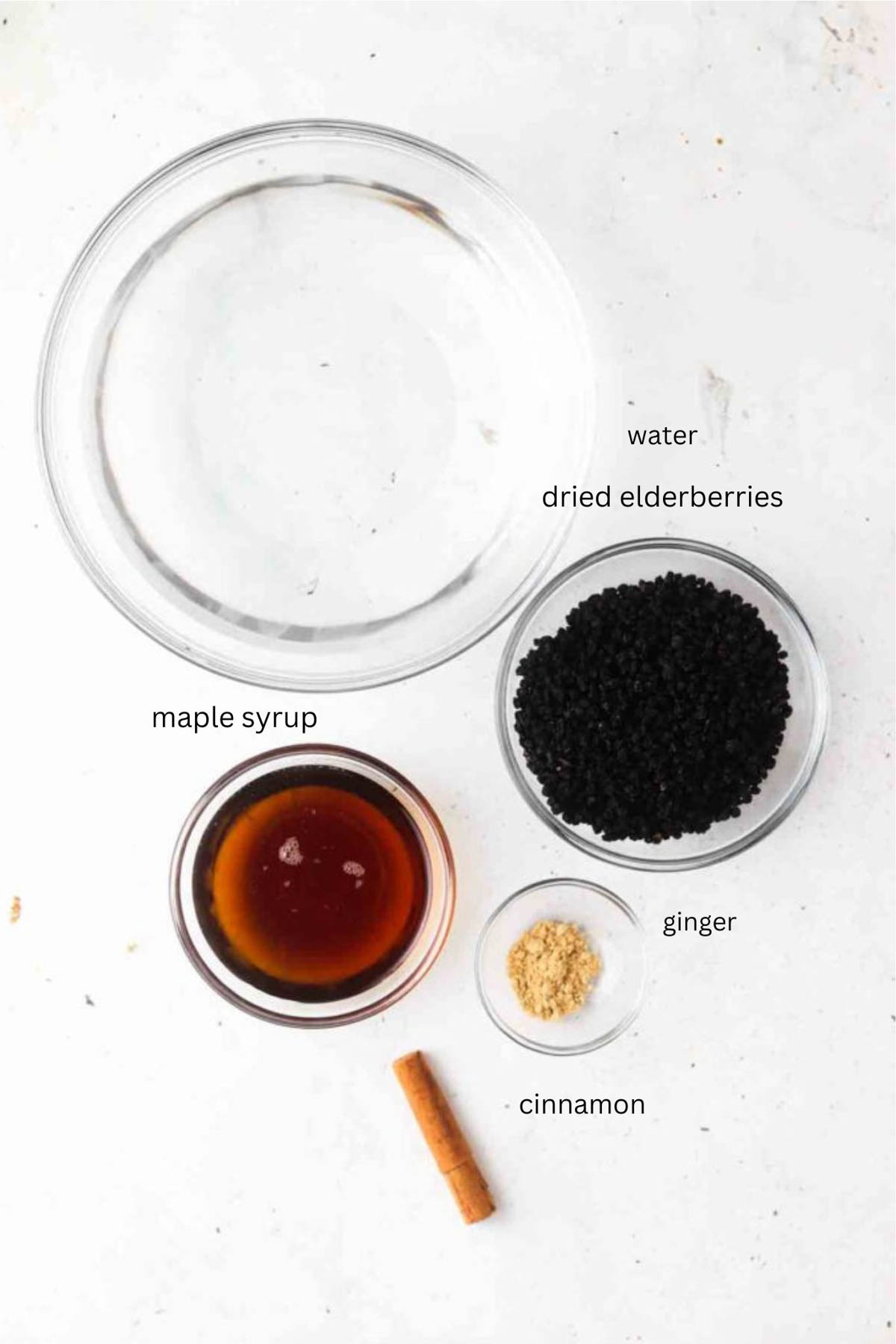 Homemade elderberry syrup ingredients in small glass bowls. 