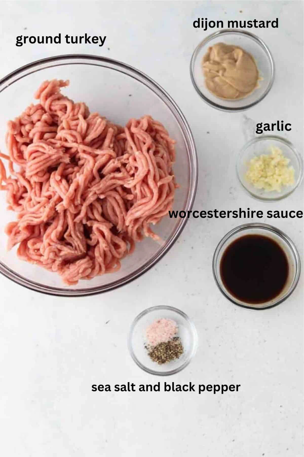 Ground turkey, dijon mustard, garlic, worcestershire sauce, sea salt, and black pepper in glass bowls.