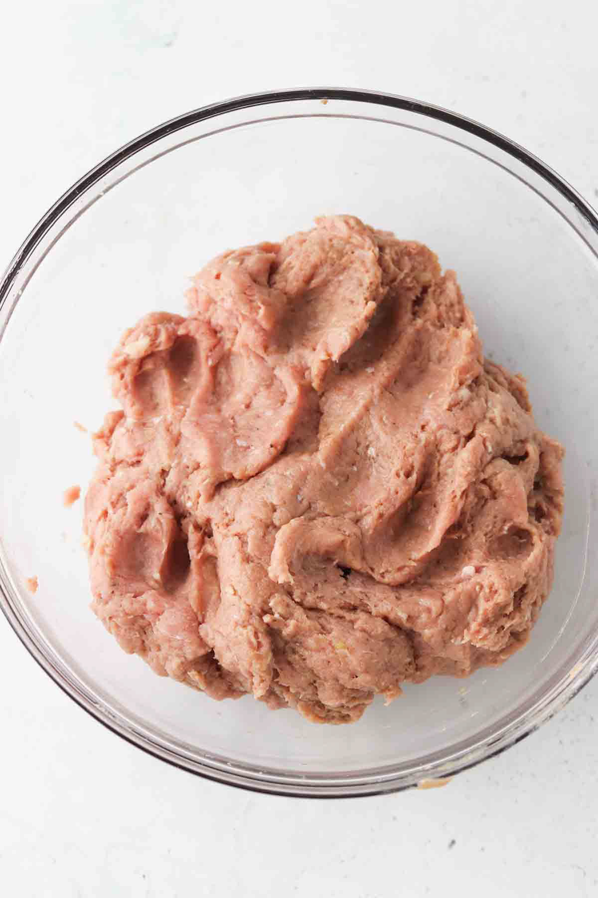 Combined turkey burger mixture in a glass mixing bowl.