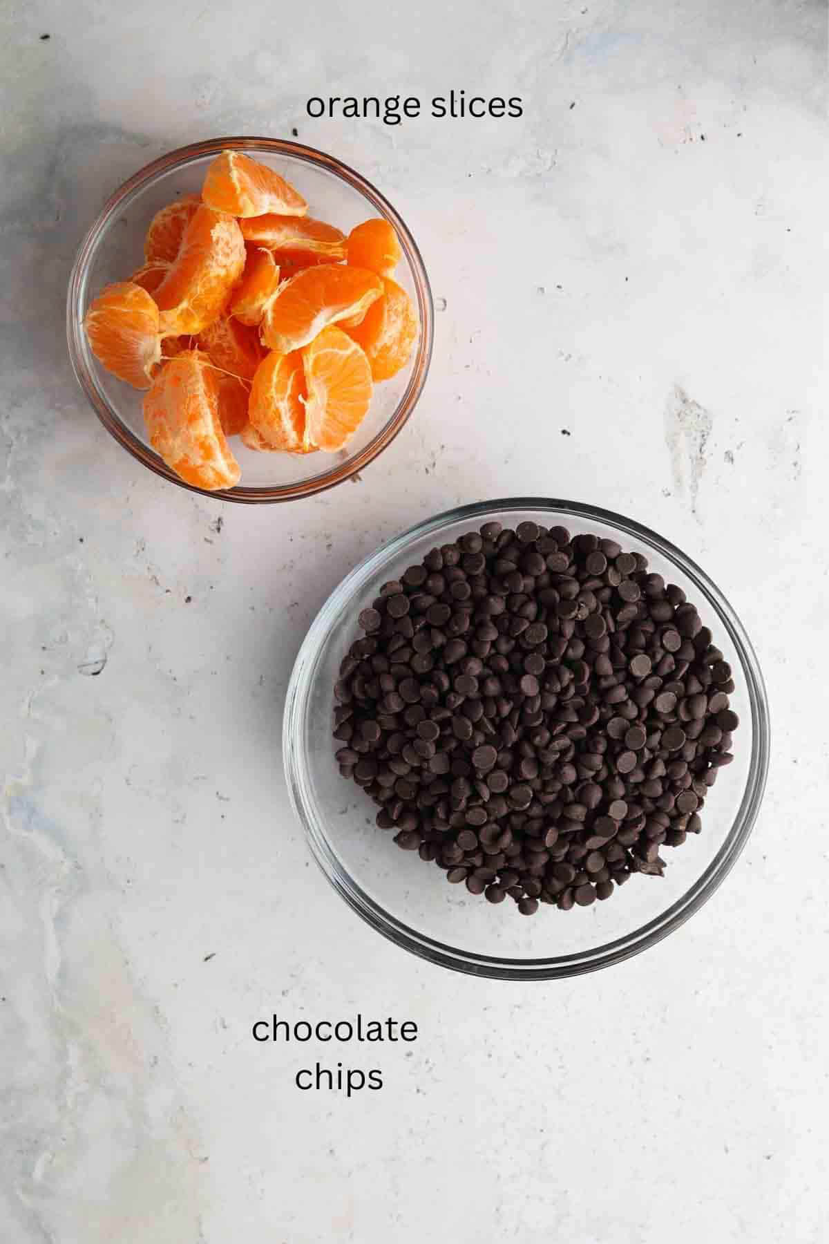 Ingredients to make chocolate covered orange slices in two small glass bowls. 