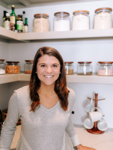 Allianna in the pantry with glass mason jars behind her.