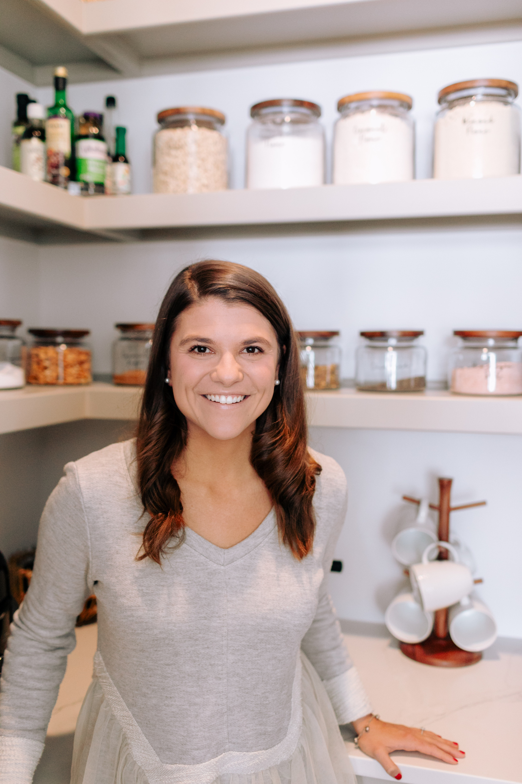 Allianna in the pantry with glass mason jars behind her.