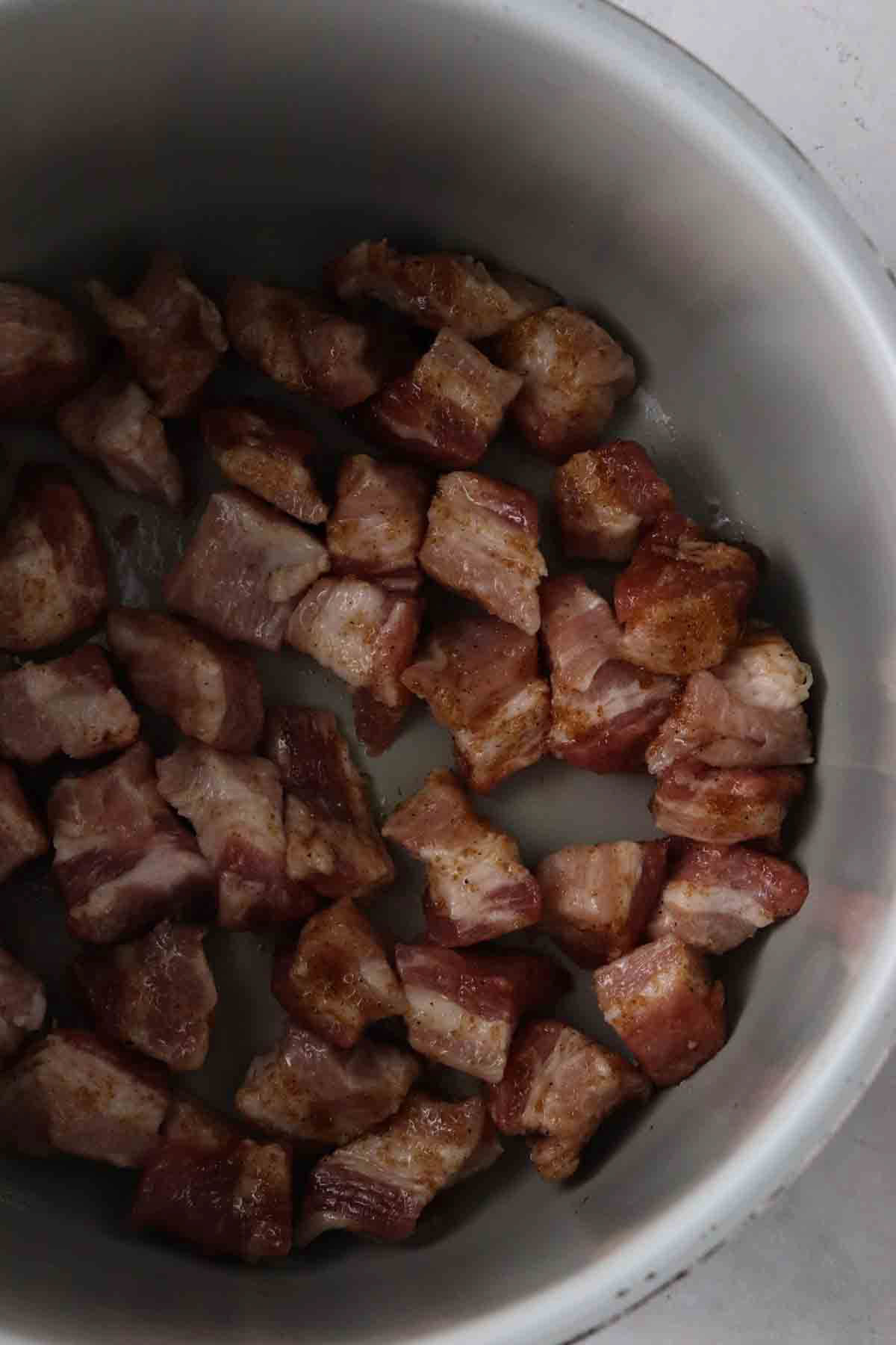 Cooked pork belly cubes inside of the the air fryer. 