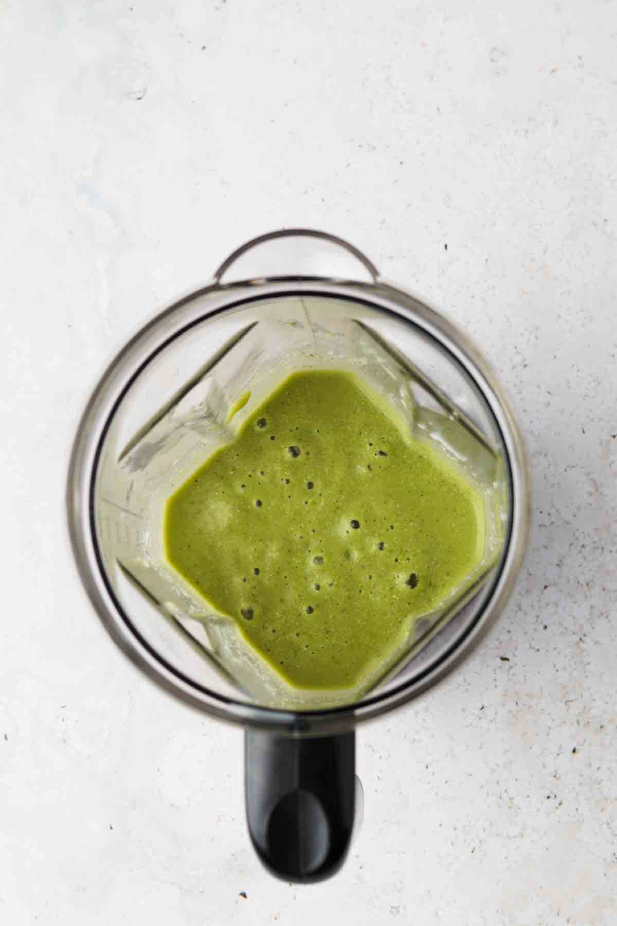 Blended broccoli smoothie in the blender base.