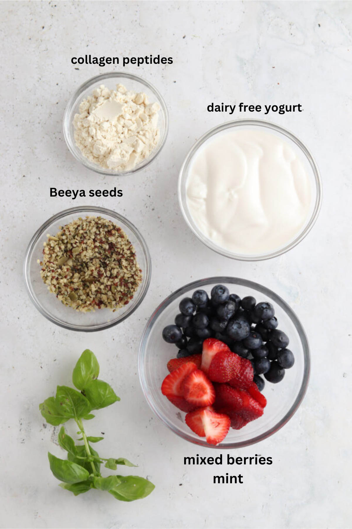 Strawberry blueberry smoothie ingredients in small glass bowls.