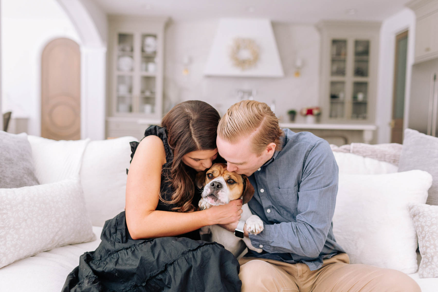 Allianna sitting on couch with husband and dog. 