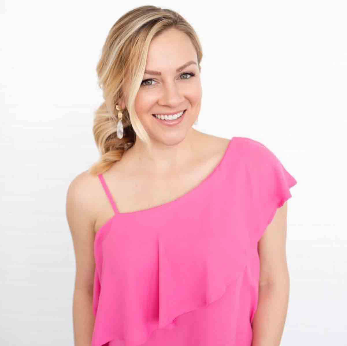 Picture of Kelly Brennan, former news reporter in a pink shirt with her hair pulled back.