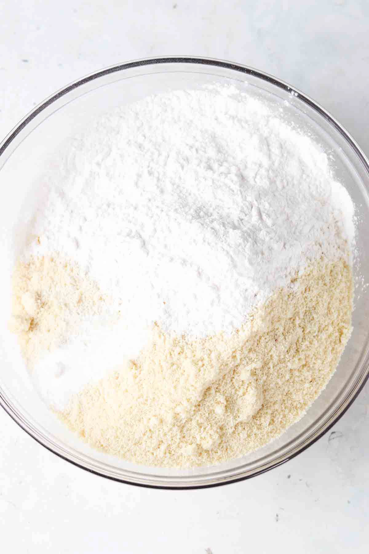 Almond flour, arrowroot powder, baking soda and salt in a clear glass bowl.