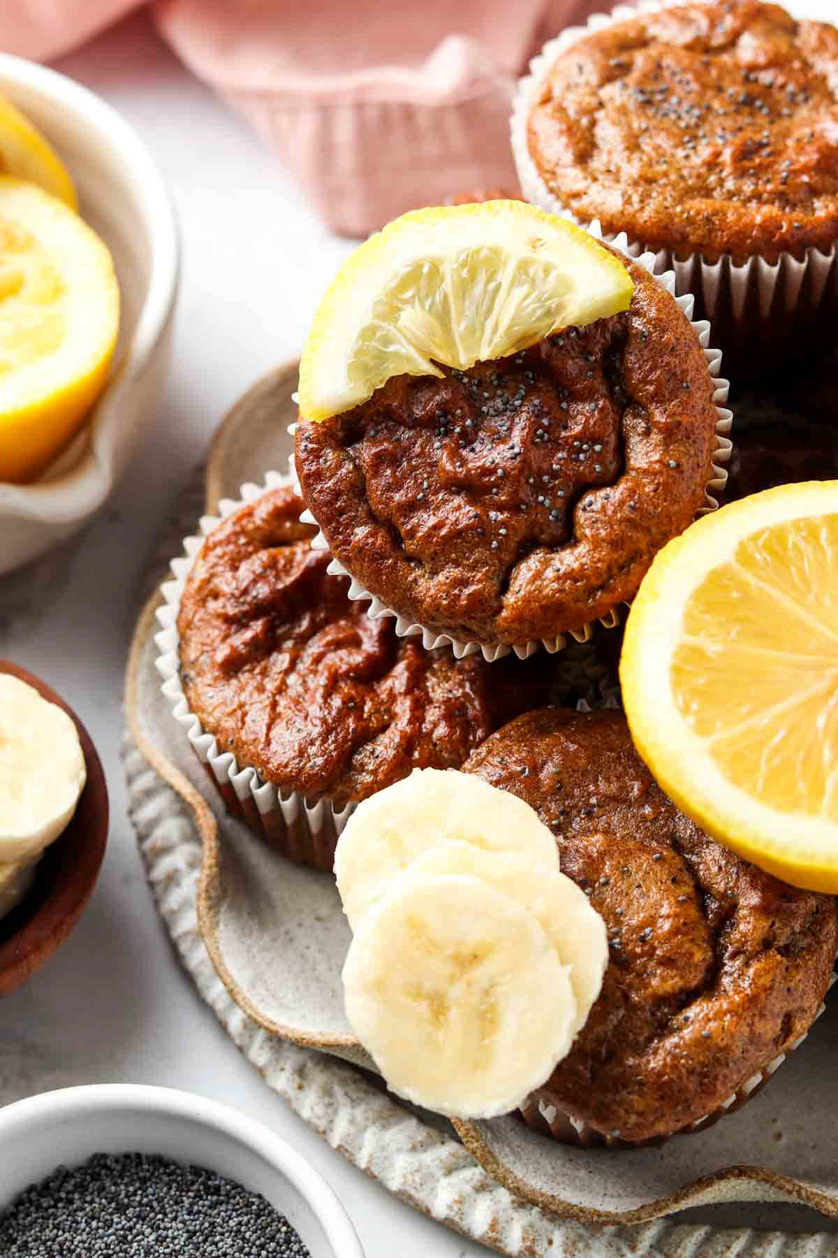 Lemon poppyseed muffins on a plate garnished with fresh lemon. 