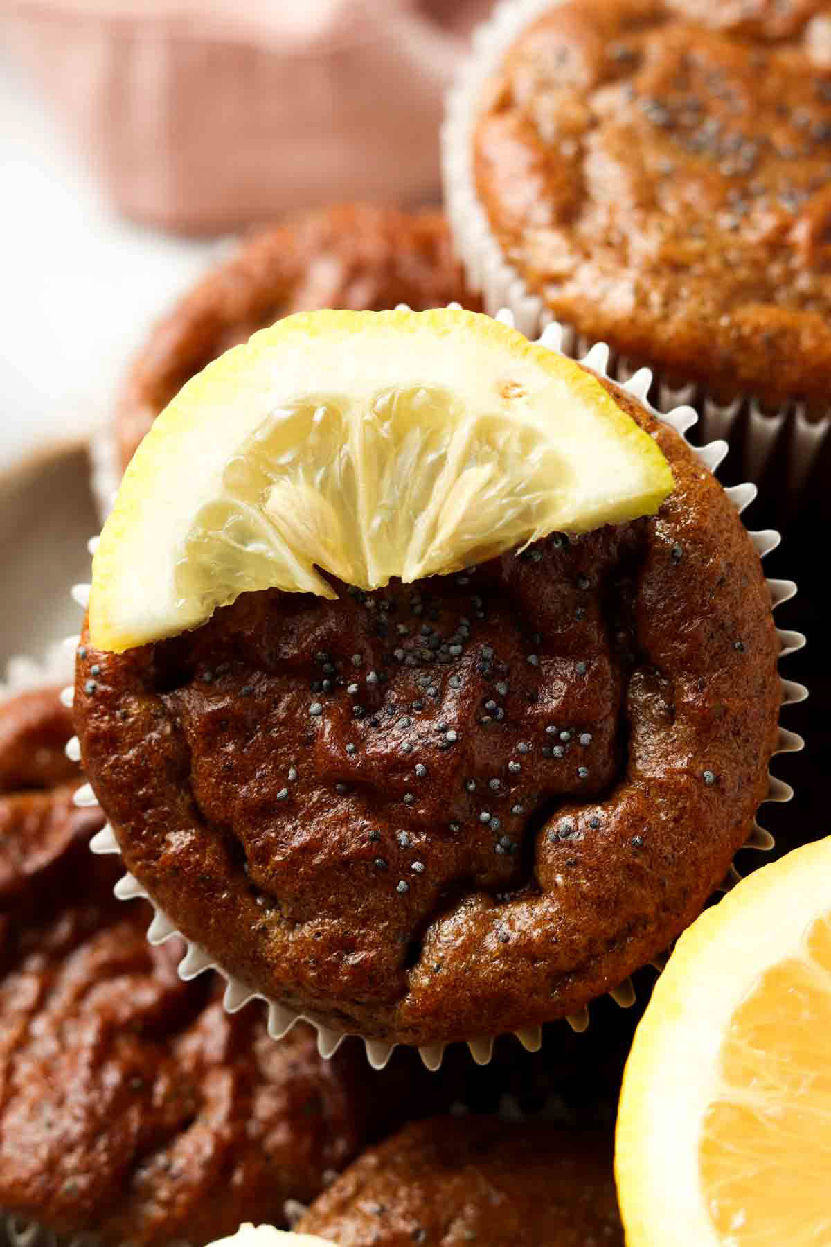 Lemon poppyseed muffin on a plate and garnished with fresh lemon. 