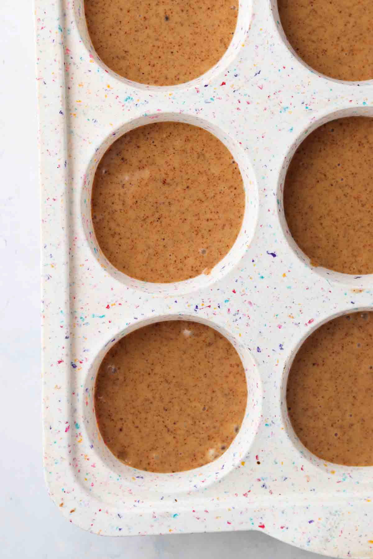 Strawberry muffin batter in a silicone muffin pan.