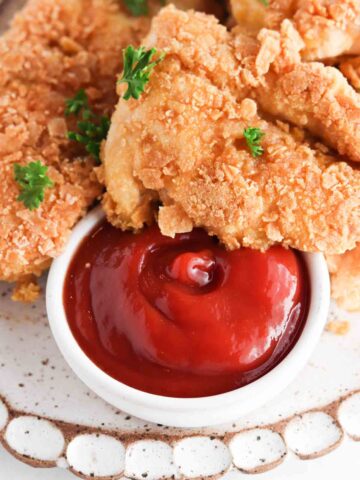 Close up picture of crispy chicken on a white scalloped plate.