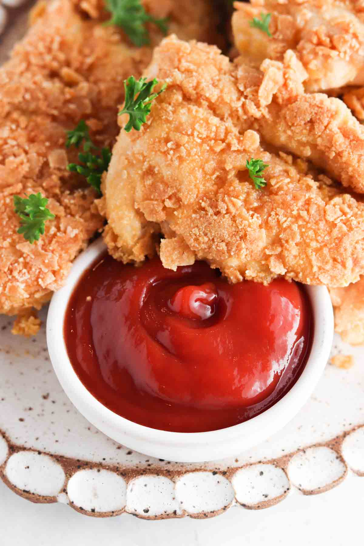 Close up picture of crispy chicken on a white scalloped plate.